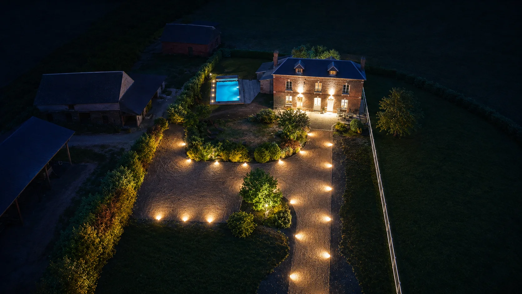 Vue nocturne de La Maison des Jonquerets et de l'allée éclairée